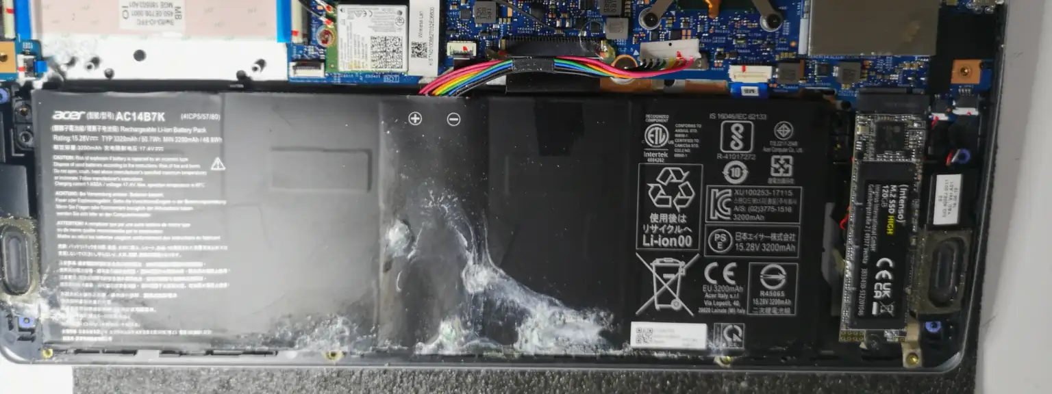 Ανοιχτό laptop Acer με χαλασμένη μπαταρία δίπλα στον SSD