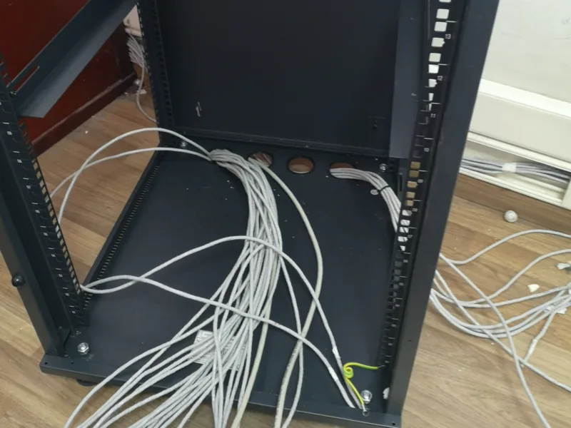 Ανοιχτό rack δικτύου με δεσμίδες καλωδίων που μπαίνουν από κάτω