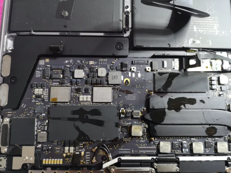 Εσωτερικό MacBook με υπολείμματα καφέ πάνω στη μητρική